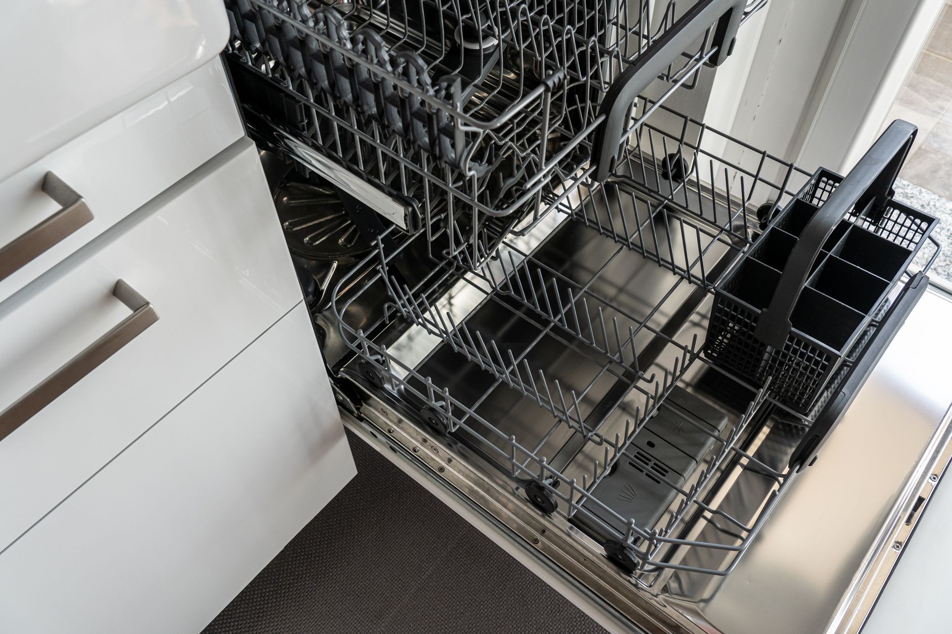 Person fixing a kitchen dishwasher