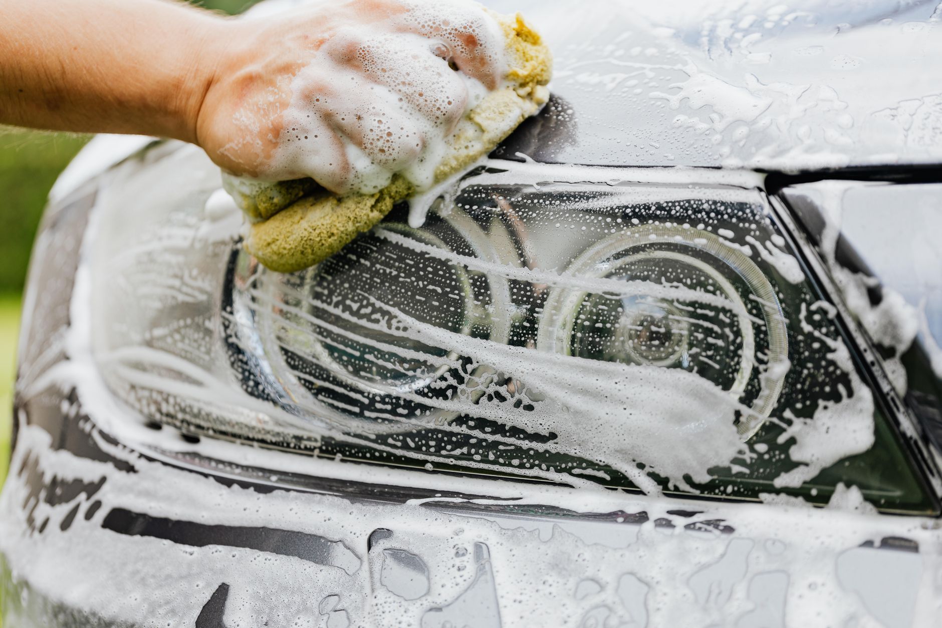 man cleaning car headlight