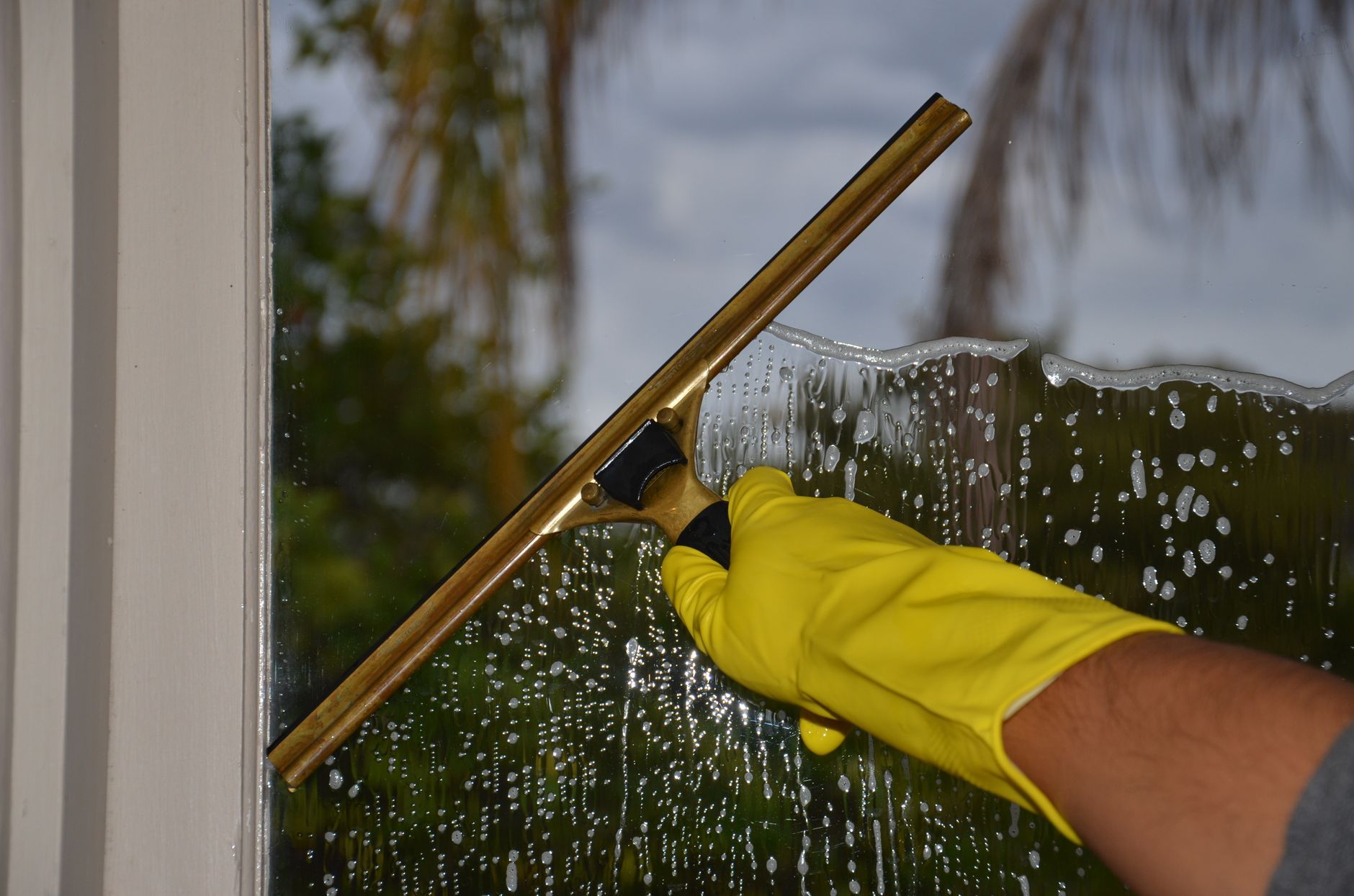 Woman using homemade cleaner to remove sticky residue from a surface