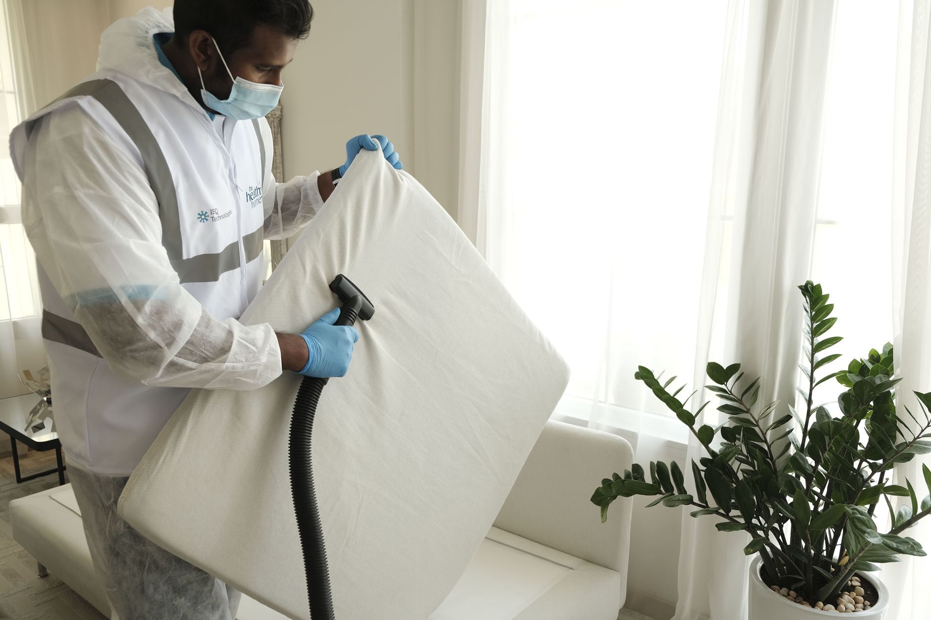 Close-up of a hand spraying mattress stain remover on a bed